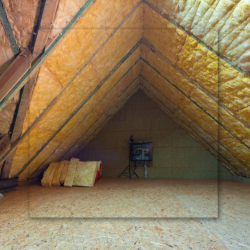 Attic interior with insulation, plywood floor, and a small electrical box.
