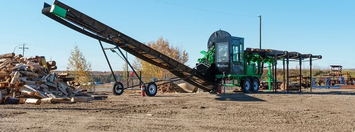 Large industrial Firewood Processing Machine with conveyor system operating outdoors.