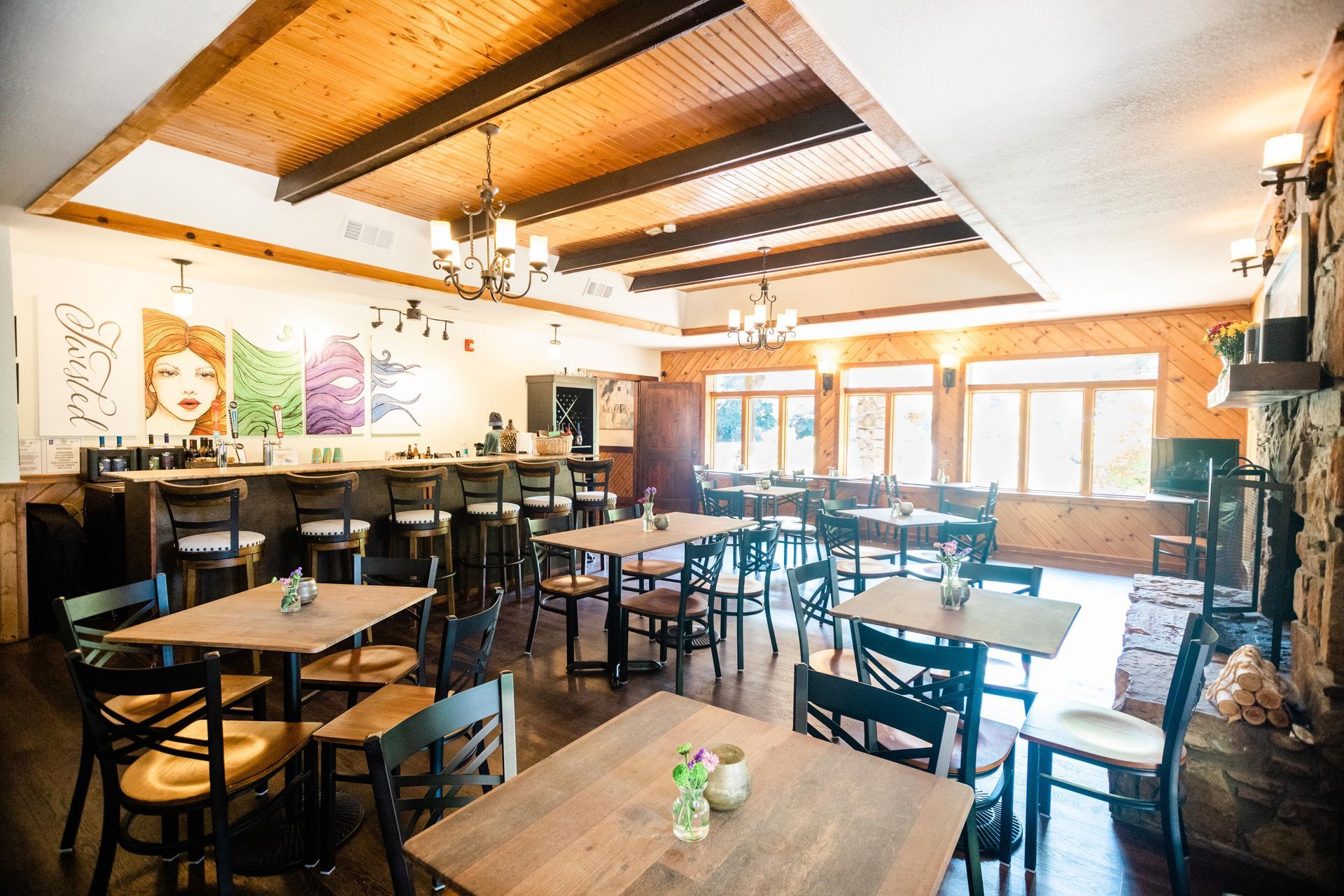 A large room with tables and chairs and a fireplace.