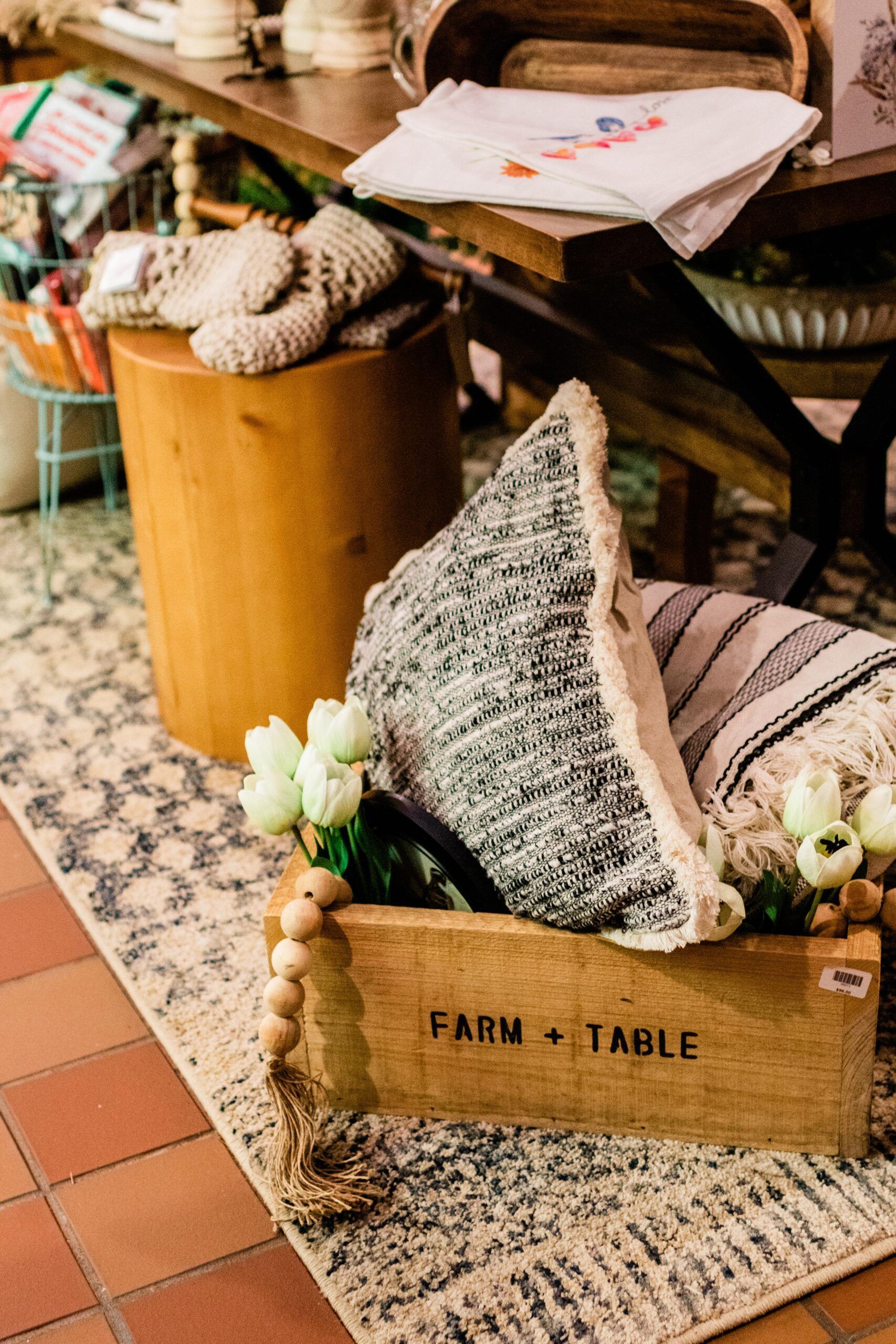 A wooden box filled with a pillow and flowers is sitting on a rug.