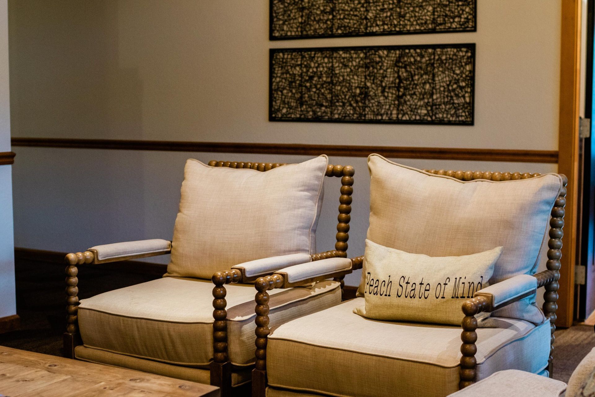 Two chairs in a living room with a pillow that says each state at stake