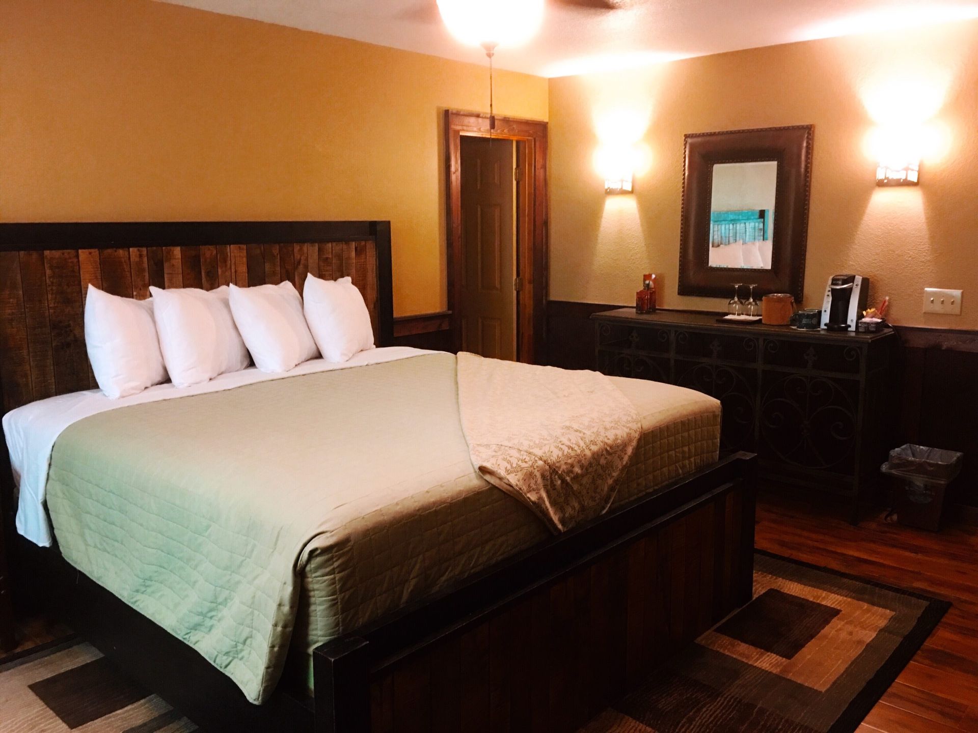 A hotel room with a large bed and a mirror