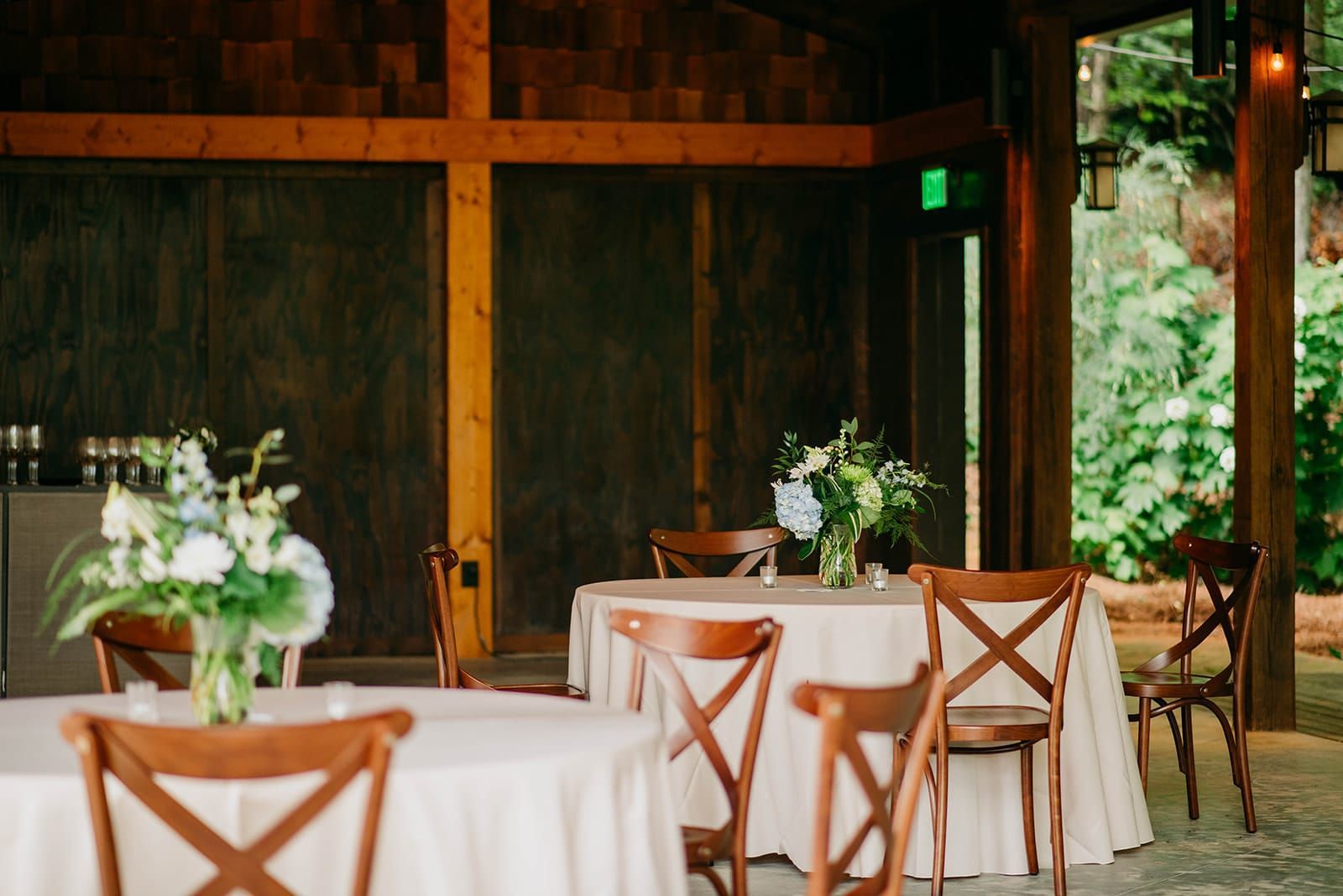 A room with tables and chairs set up for a wedding reception.