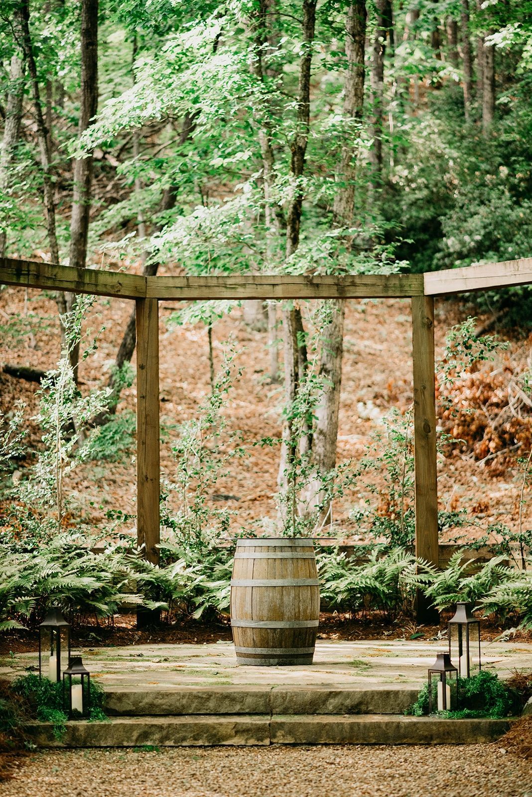There is a wooden barrel in the middle of the woods.