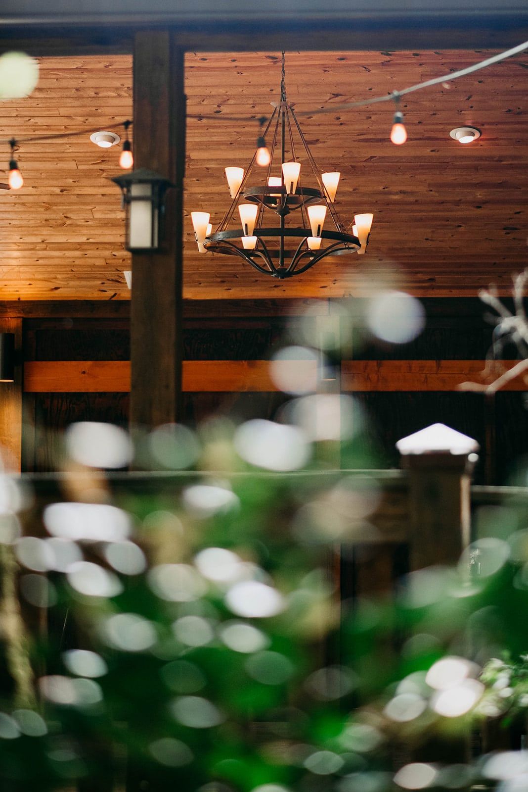 A chandelier is hanging from the ceiling of a wooden building.