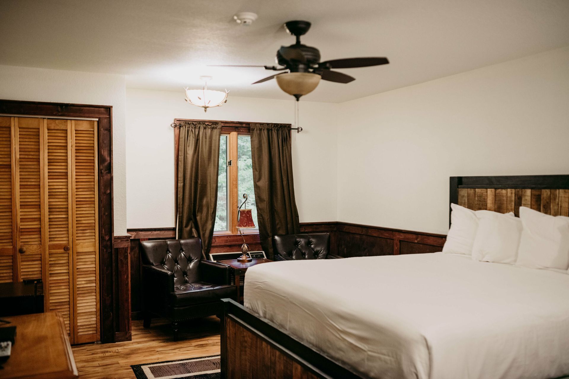 A bedroom with a king size bed and a ceiling fan.
