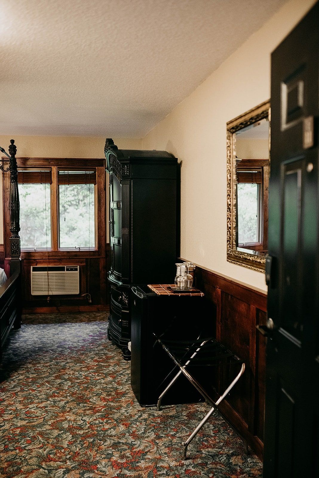 A room with a black door and a mirror on the wall.