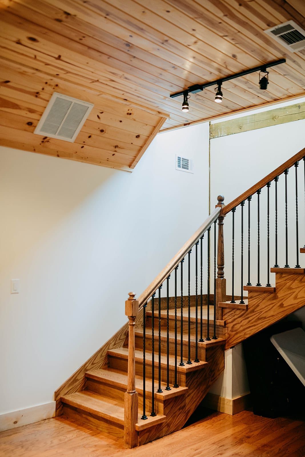 A wooden staircase with a metal railing in a house.