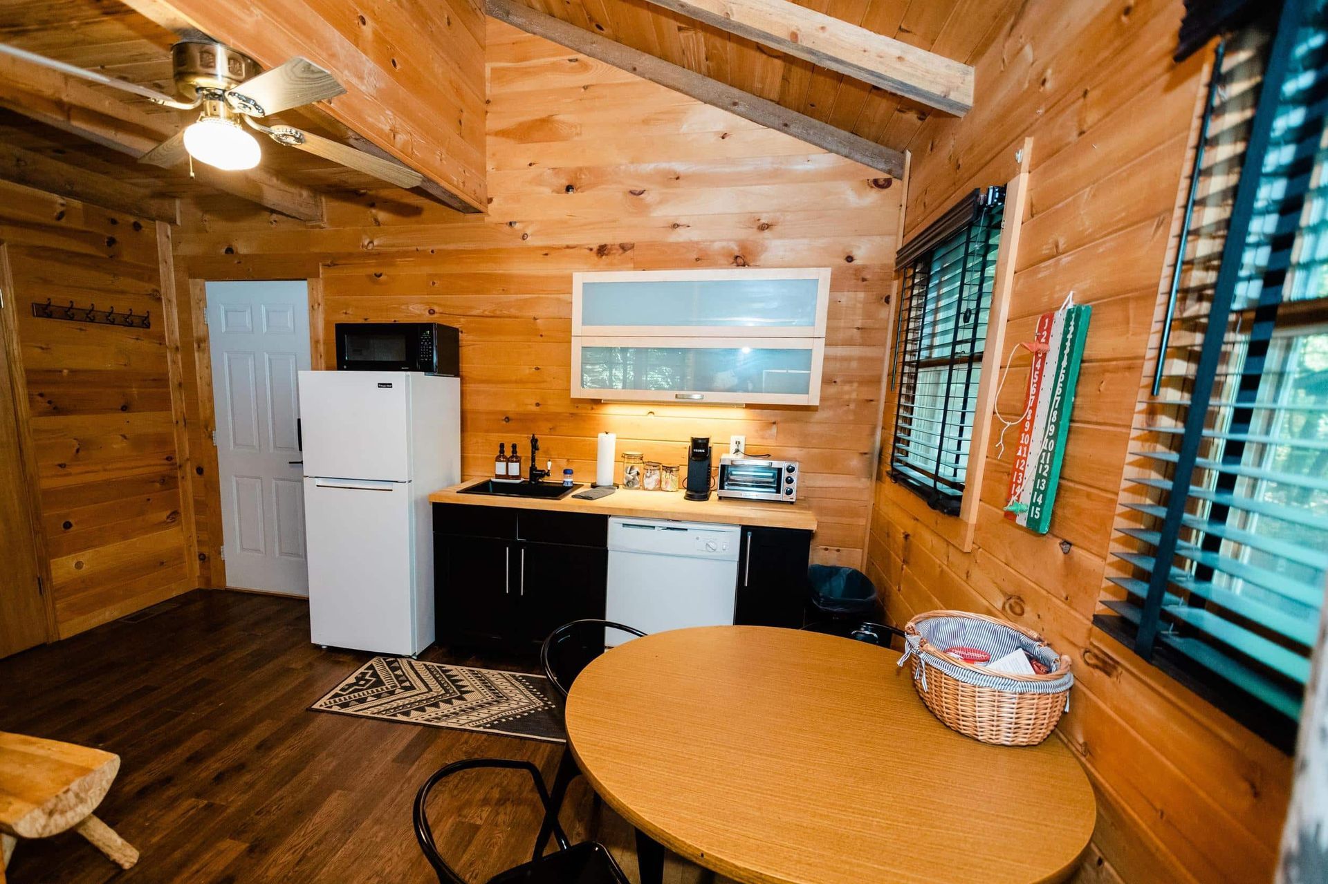 A small kitchen in a log cabin with a table and chairs.