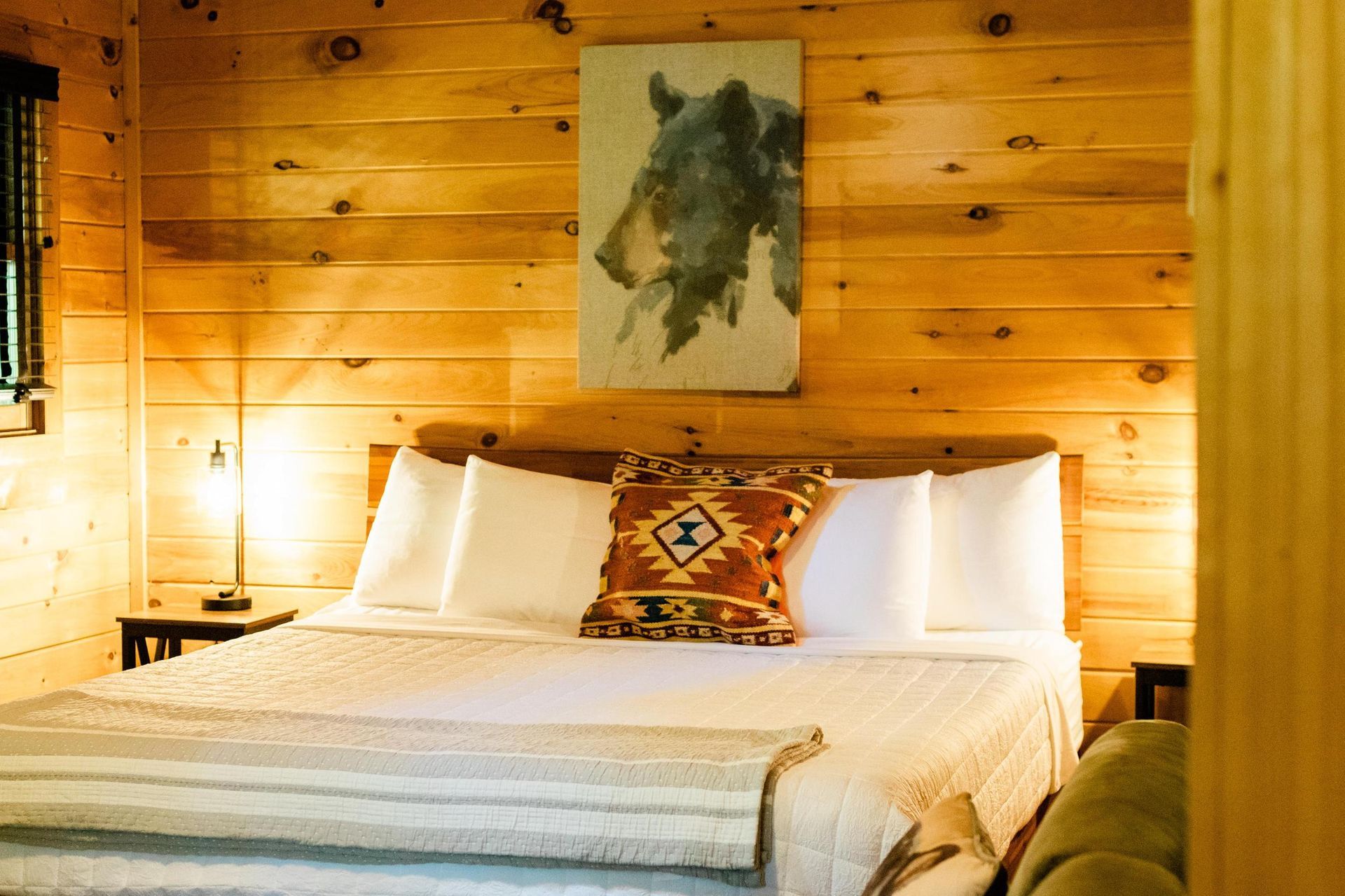 A bedroom with a bed and a painting on the wall.