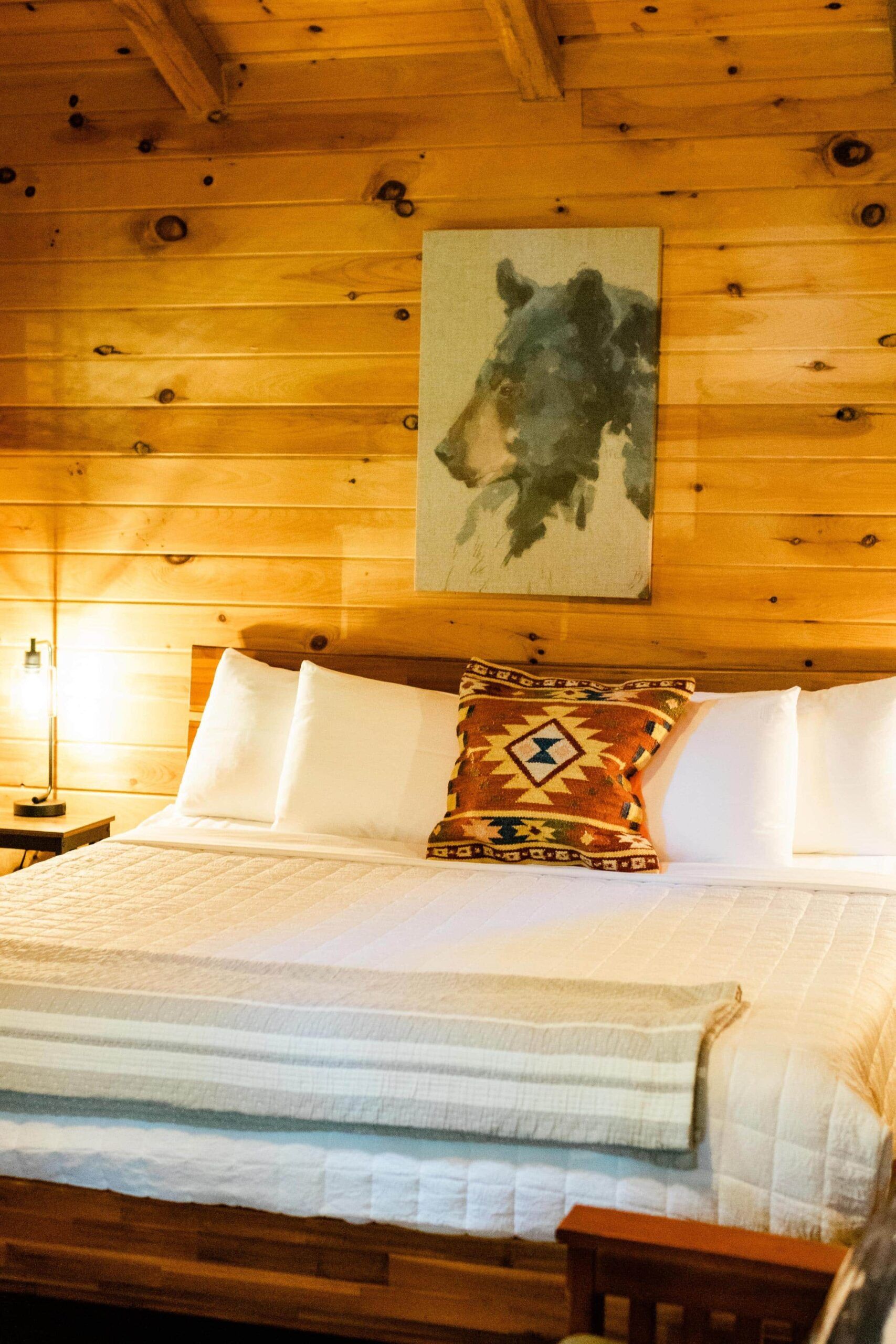 There is a painting of a bear on the wall above the bed.