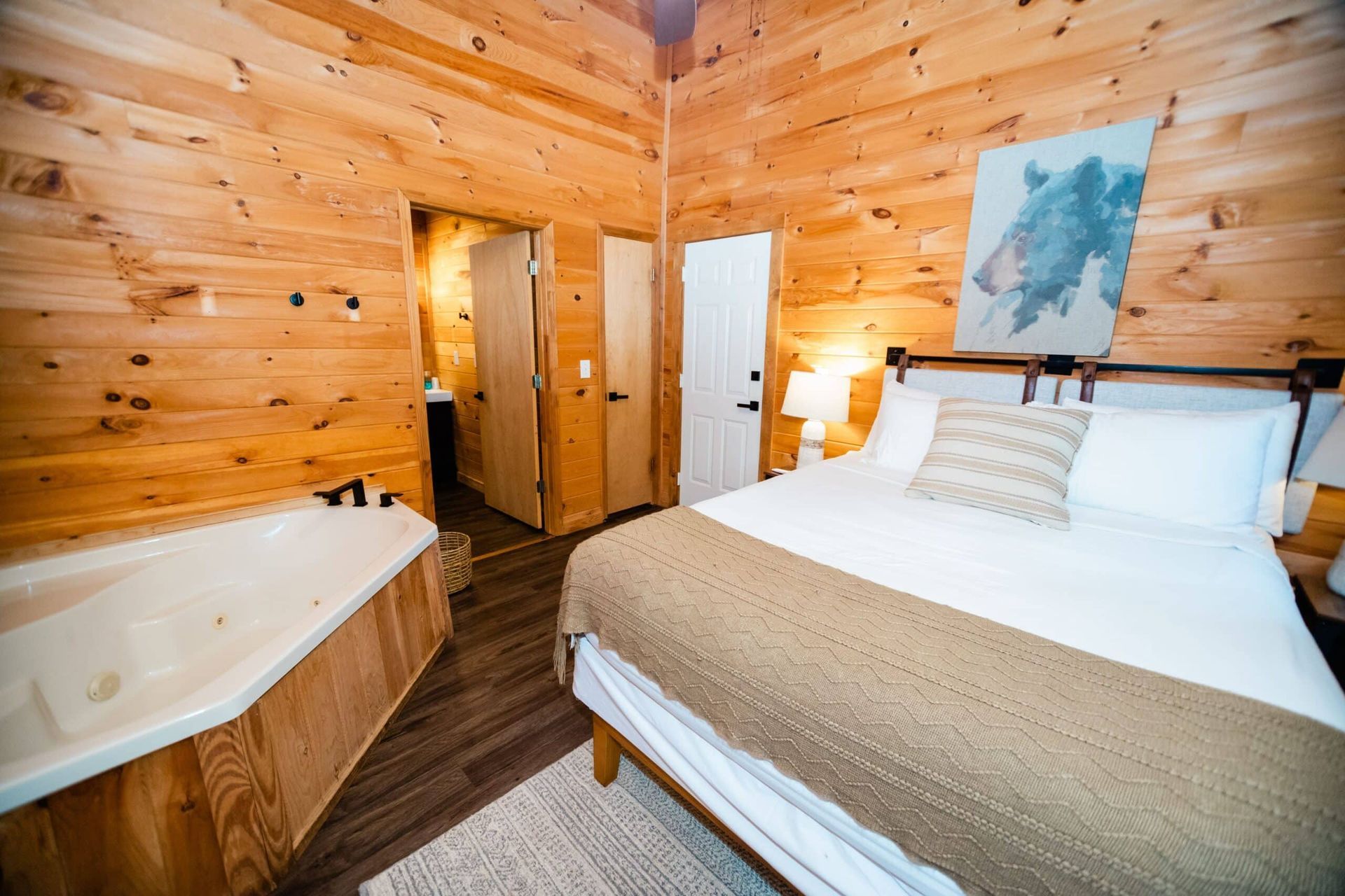 A bedroom in a cabin with a bed and a bathtub.