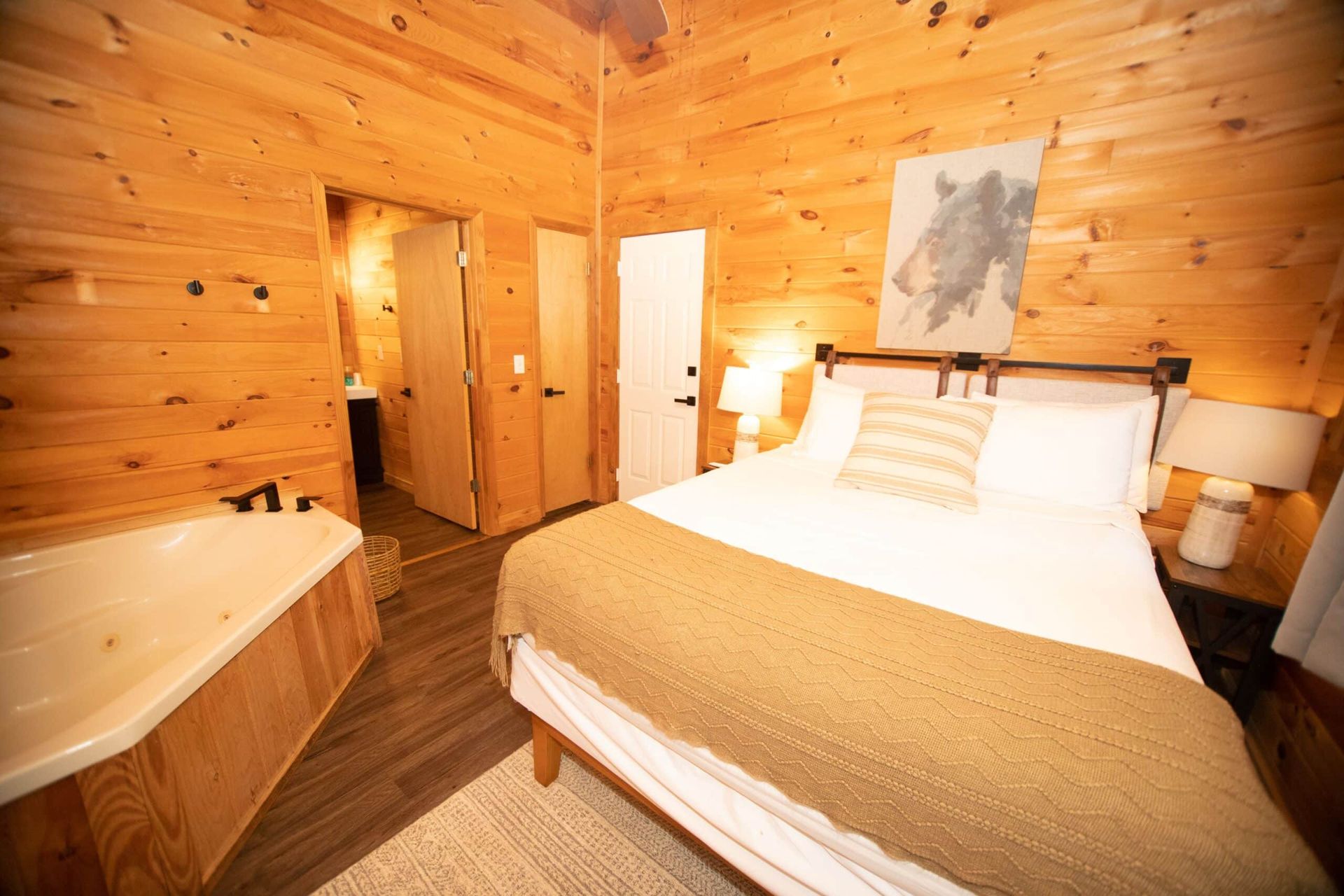 A bedroom in a cabin with a bed and a bathtub.