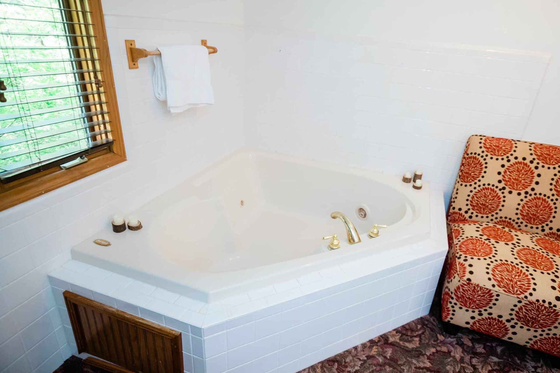 A bathroom with a jacuzzi tub and a chair.