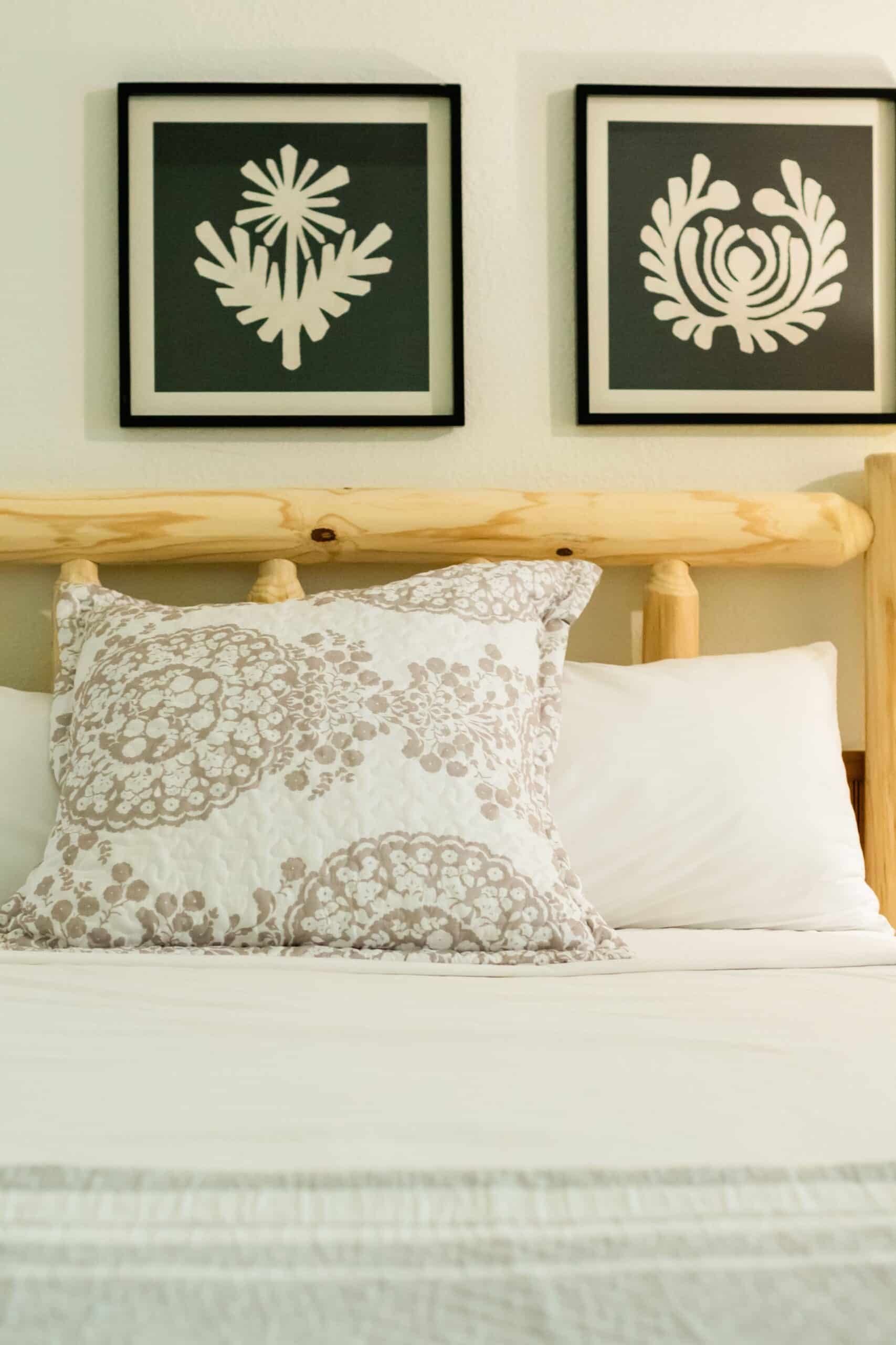 A bed with two pictures on the wall above it