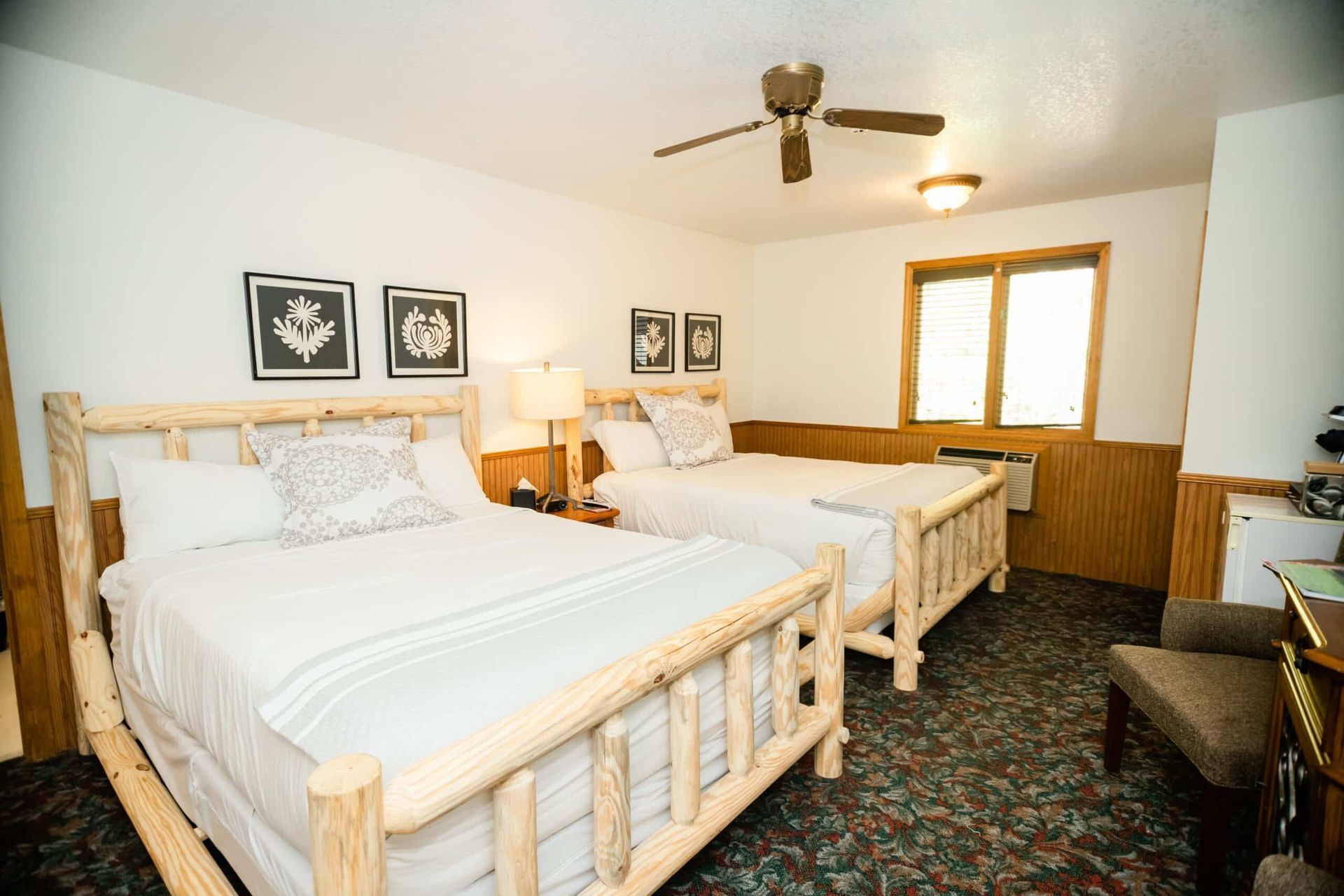 A hotel room with two beds and a ceiling fan.