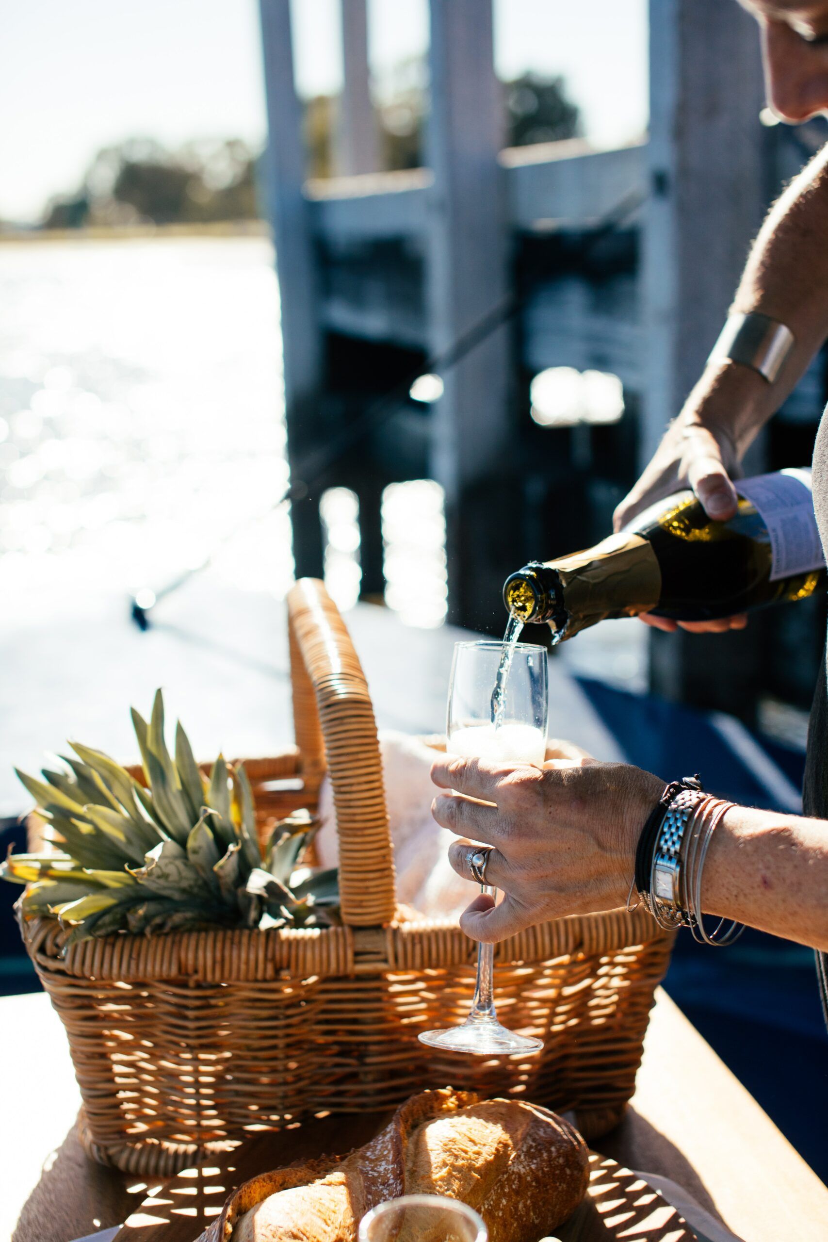 A woman is pouring champagne into a glass from a bottle.