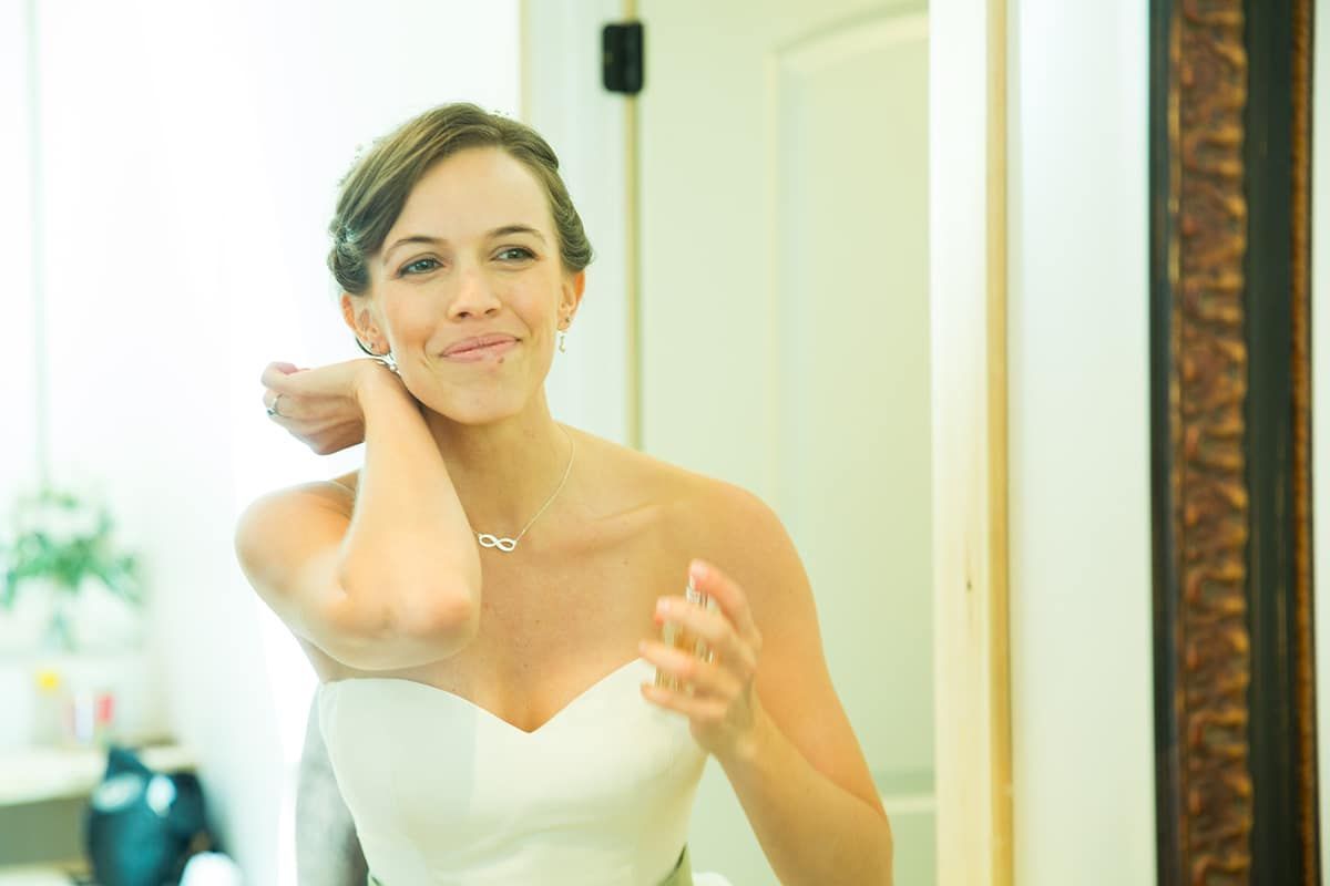 A woman in a wedding dress is looking at herself in a mirror.
