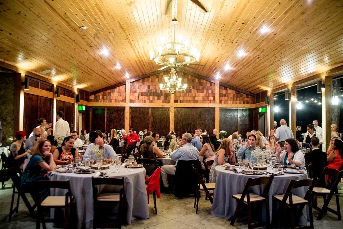 A large group of people are sitting at tables at a wedding reception.