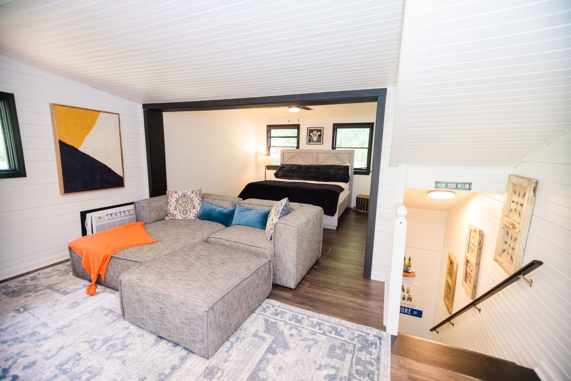 A living room with a couch and stairs leading to a bedroom.