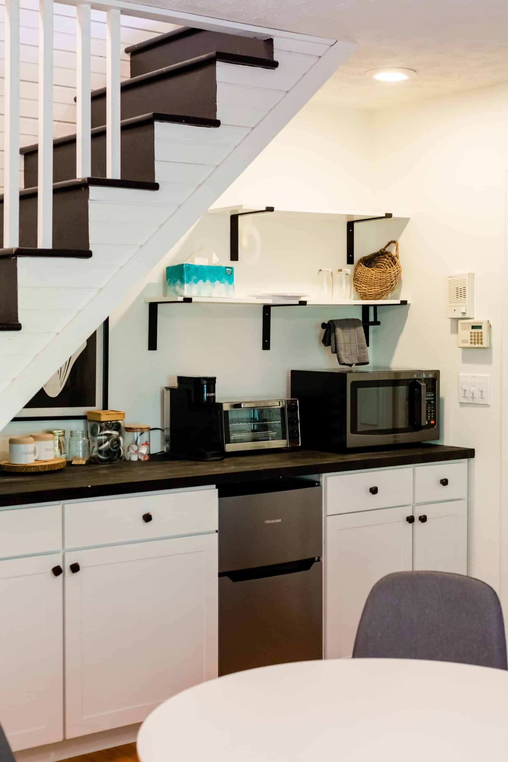 A kitchen with stairs leading up to the second floor