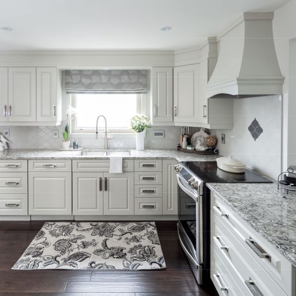 A kitchen with white cabinets and granite counter tops