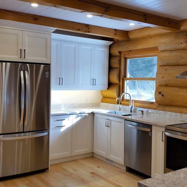 A kitchen with stainless steel appliances and white cabinets