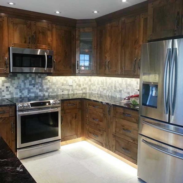 A kitchen with stainless steel appliances and wooden cabinets