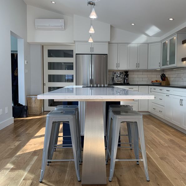 A kitchen with white cabinets and a stainless steel refrigerator