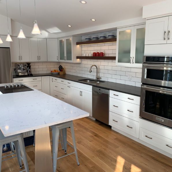 A kitchen with white cabinets and stainless steel appliances