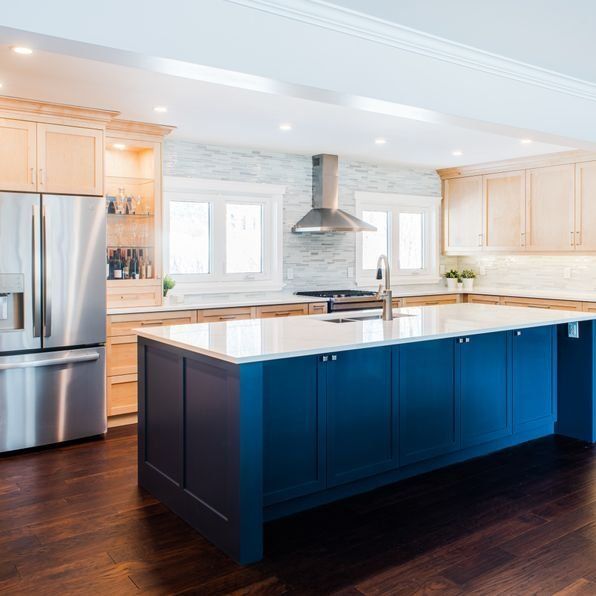 A kitchen with blue cabinets and stainless steel appliances