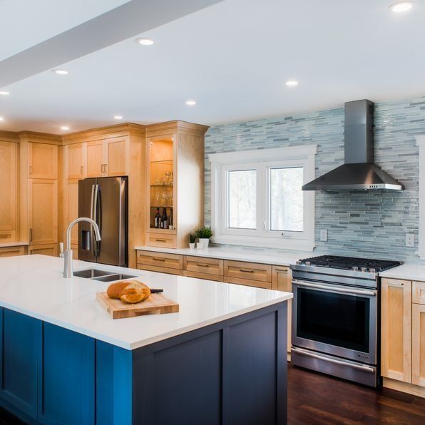 A kitchen with a blue island and white counter tops