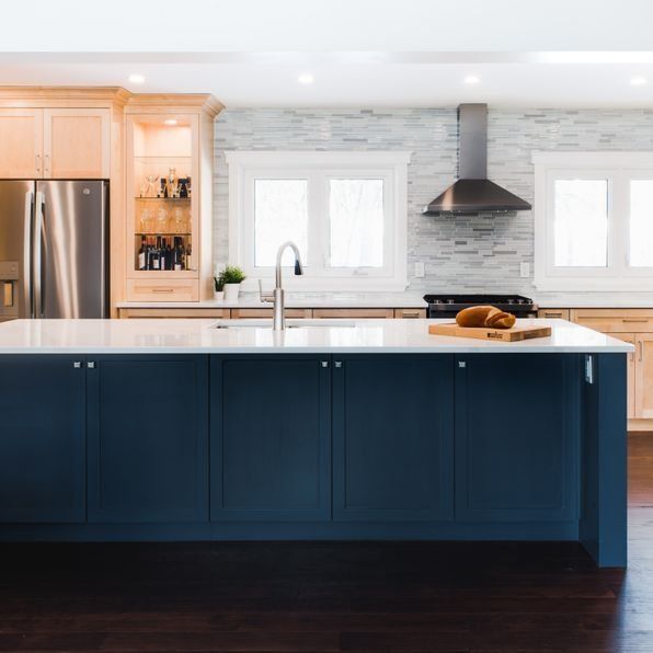 A kitchen with blue cabinets and white counter tops