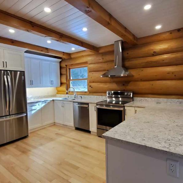 A kitchen in a log cabin with stainless steel appliances