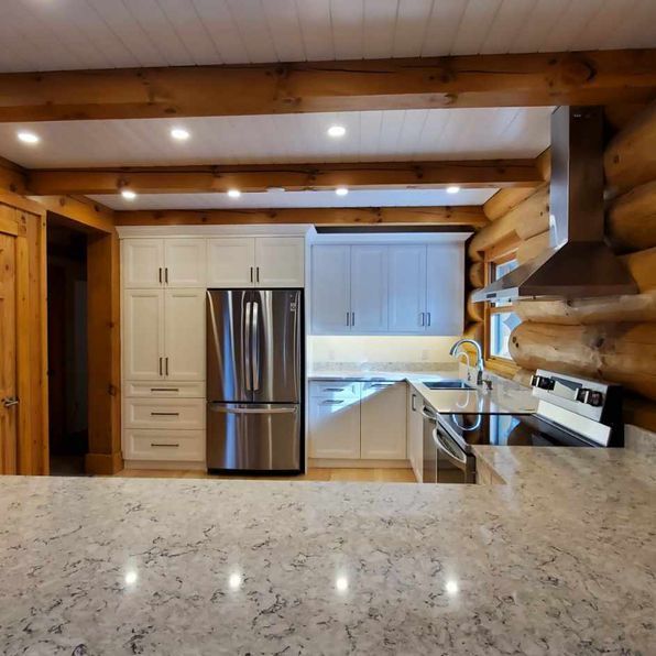A kitchen with stainless steel appliances and white cabinets