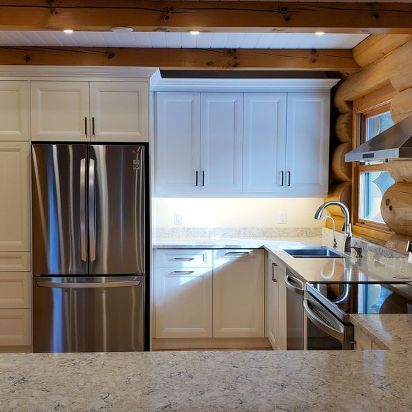 A kitchen with white cabinets and stainless steel appliances