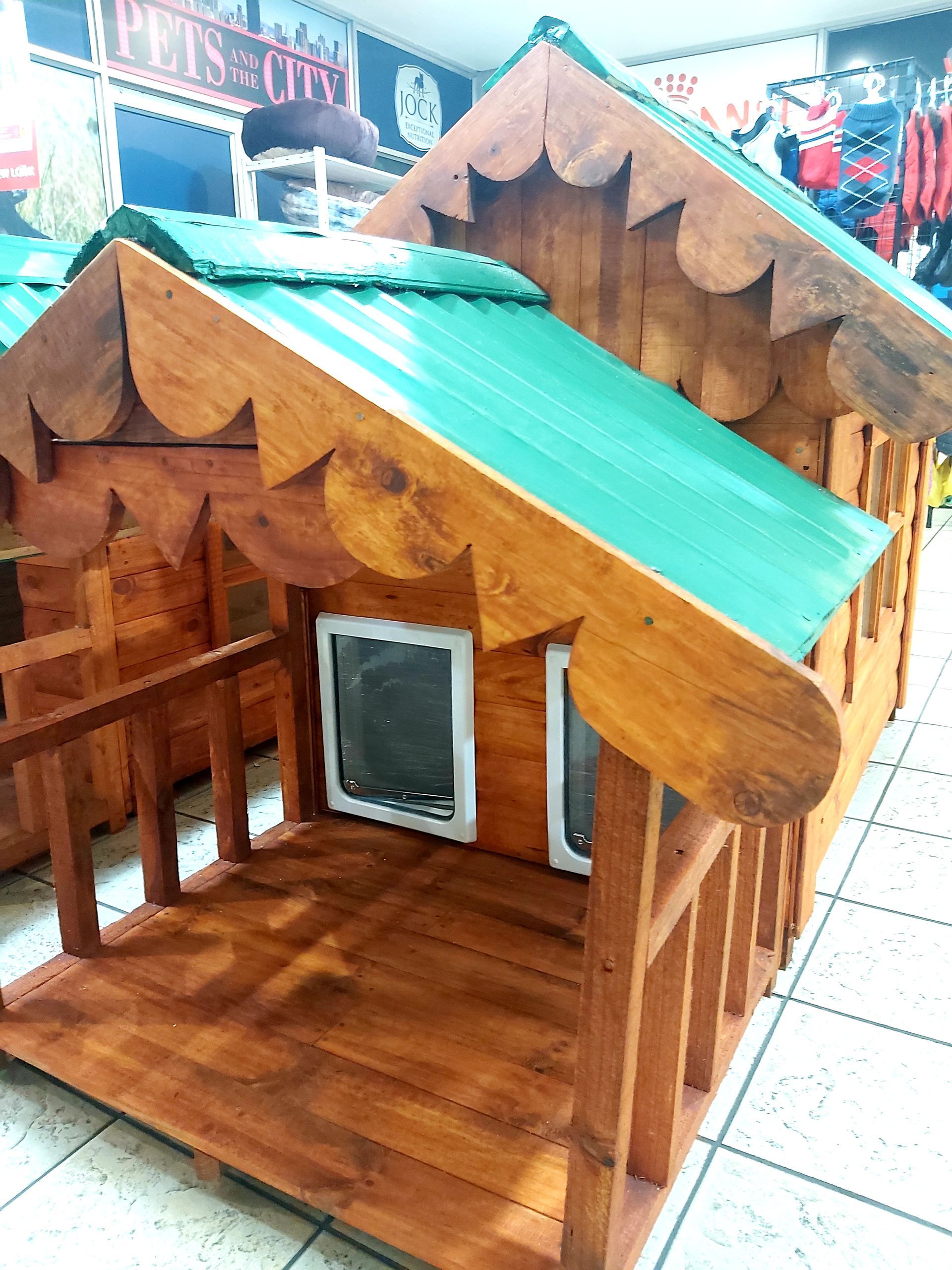 A small wooden dog house with a green roof