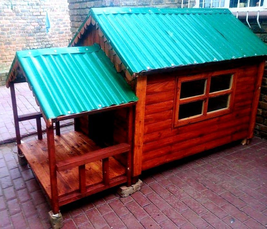 A wooden dog house with a green roof available at Pets and the City in Pretoria East.