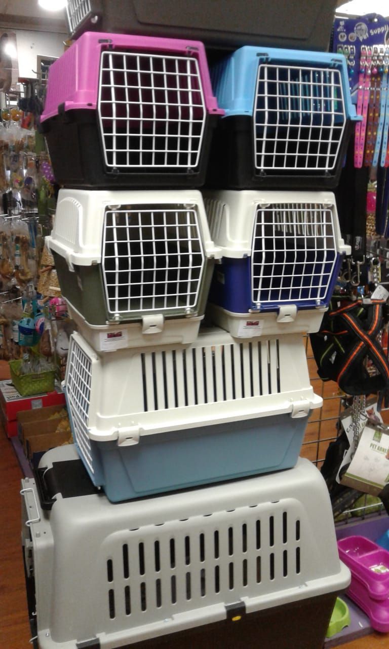 A bunch of carriers are stacked on top of each other in Pets and the City.