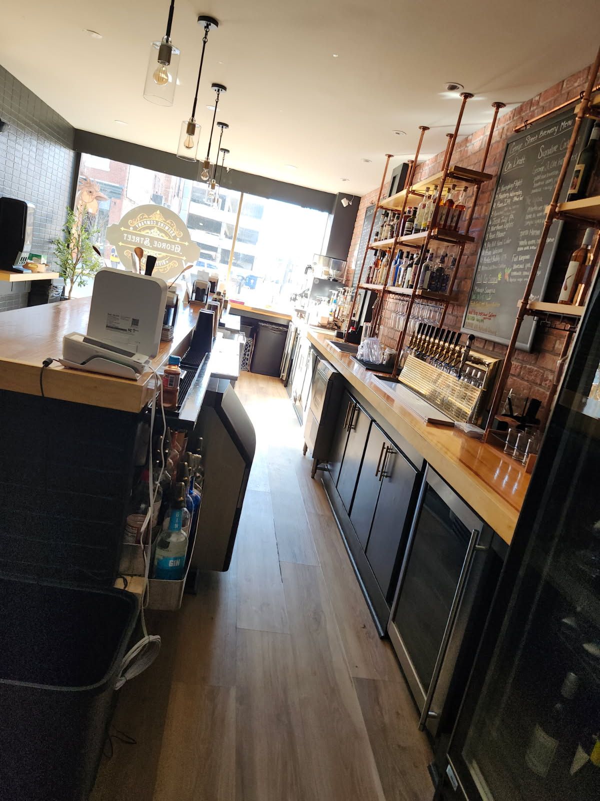 A long hallway in a restaurant with a chalkboard on the wall.