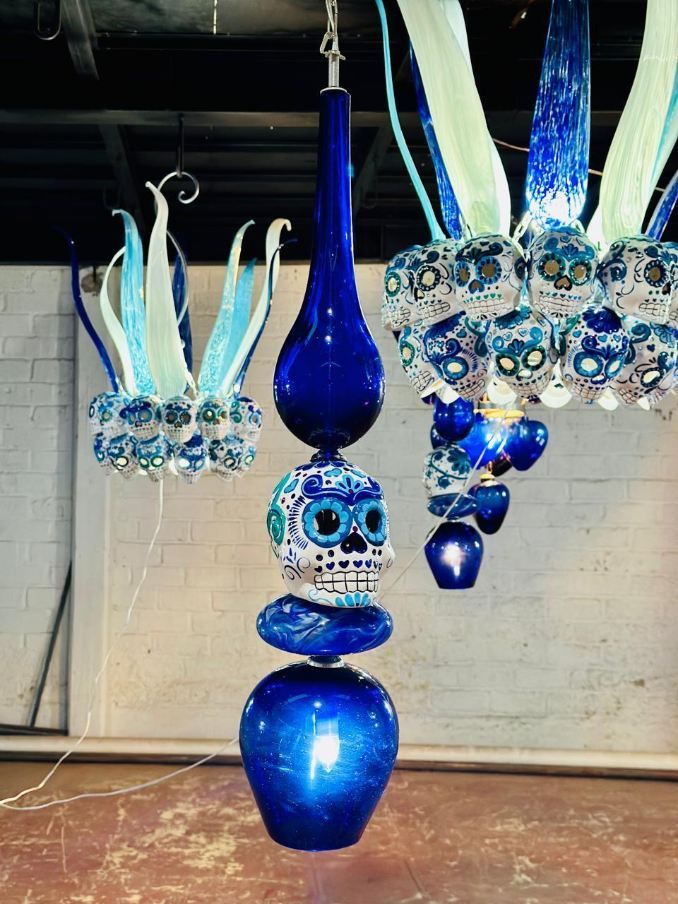 A blue vase with skulls on it is hanging from the ceiling.