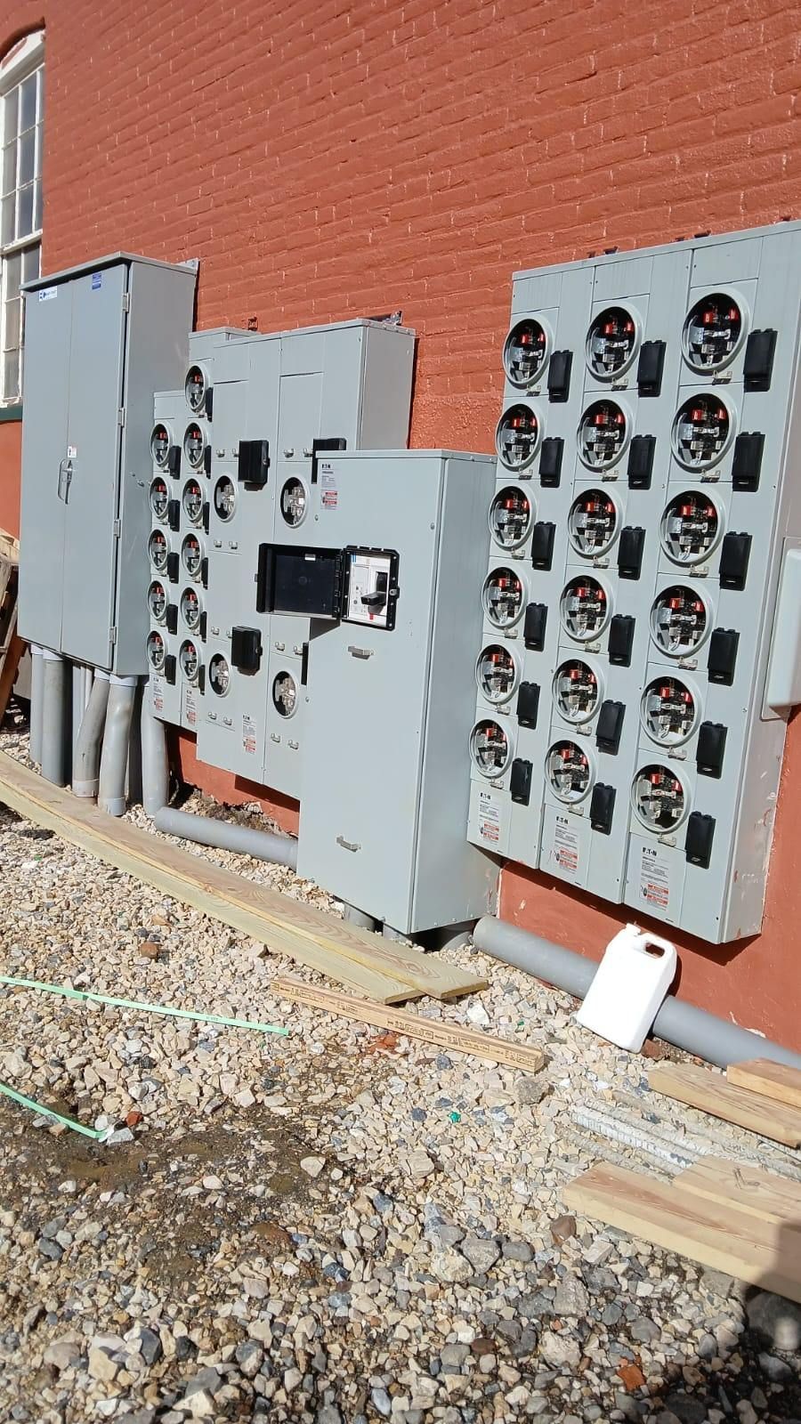 There are a lot of electrical boxes on the side of a building.
