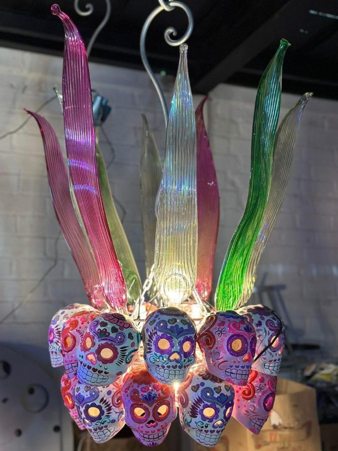 A chandelier made of sugar skulls and leaves is hanging from the ceiling.