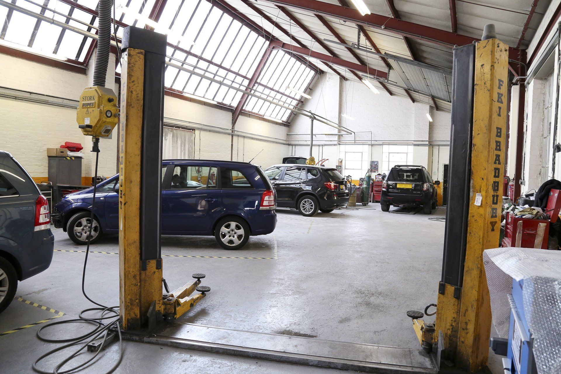 A blue car is on a lift in a garage