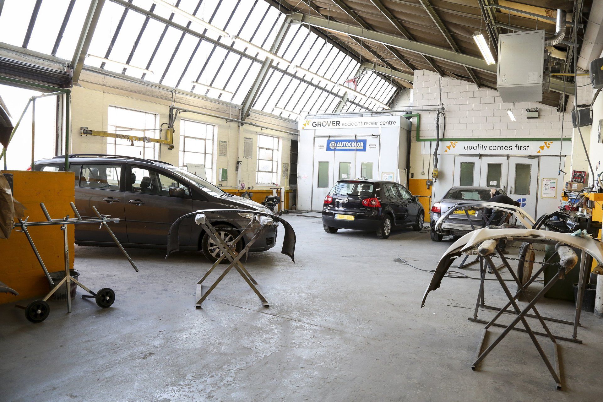 A car is being painted in a garage.