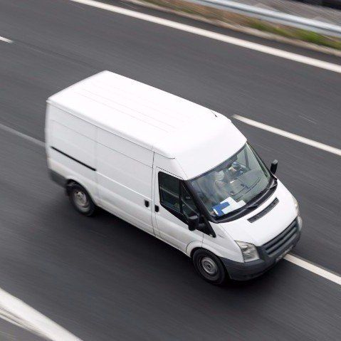 A white van is driving down a highway