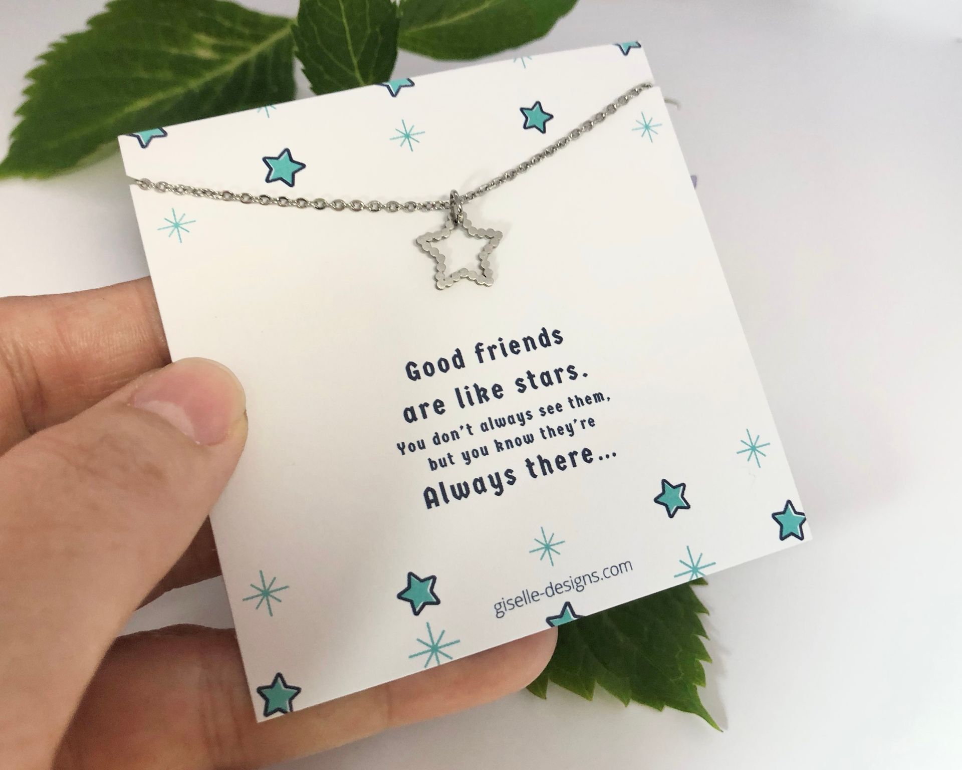 Hand holding a card with star necklace. Text reads, 