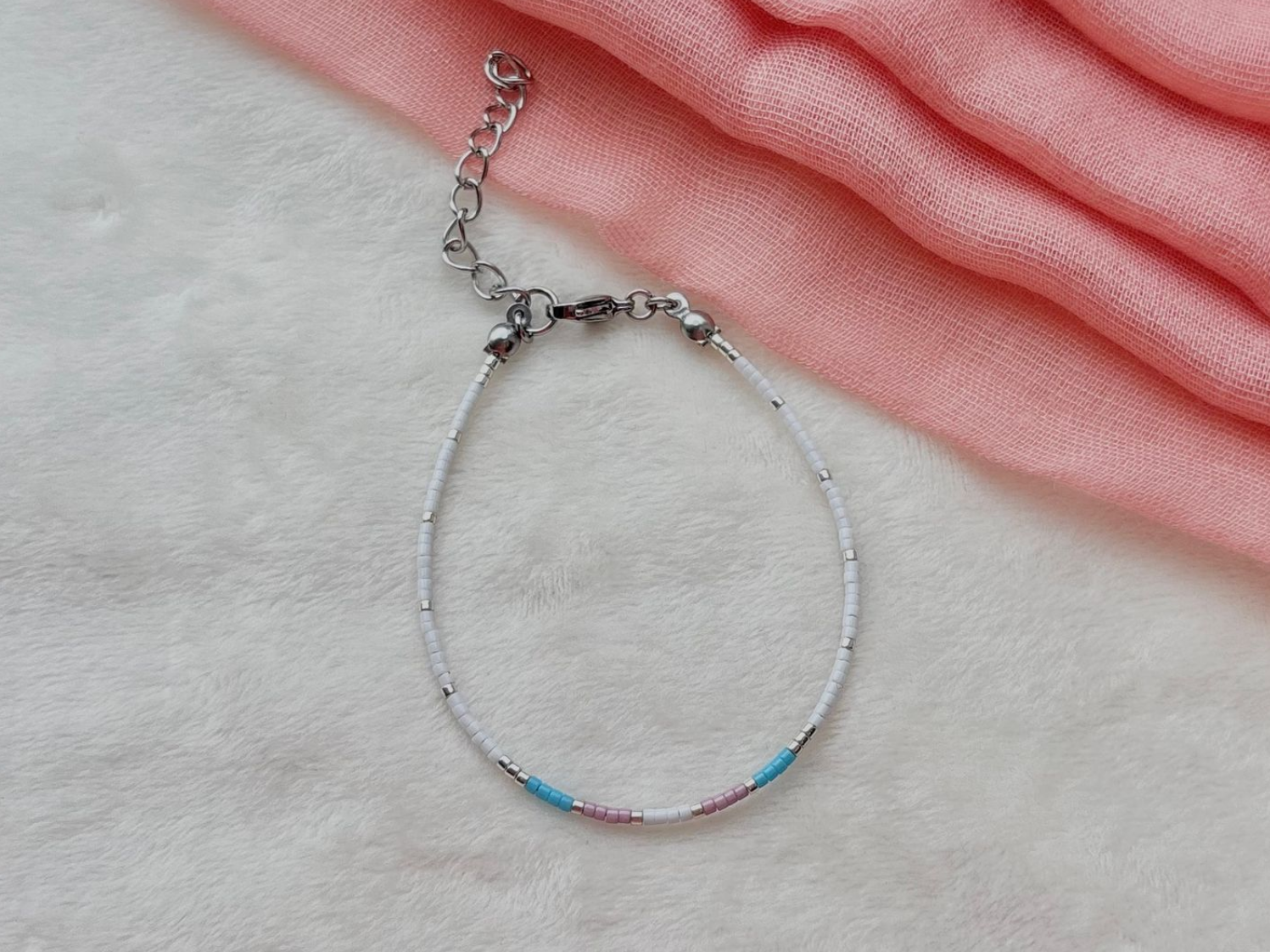 Black beaded bracelet with gold accents, blue, pink, and gold beads.