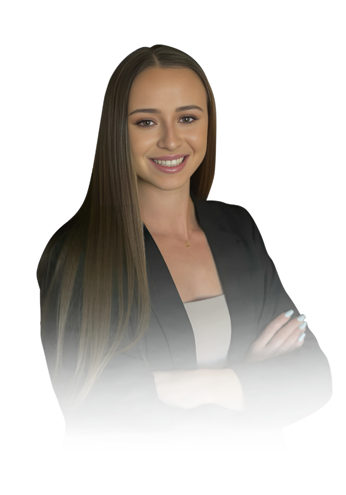 A woman with long hair is wearing a black jacket and smiling with her arms crossed.