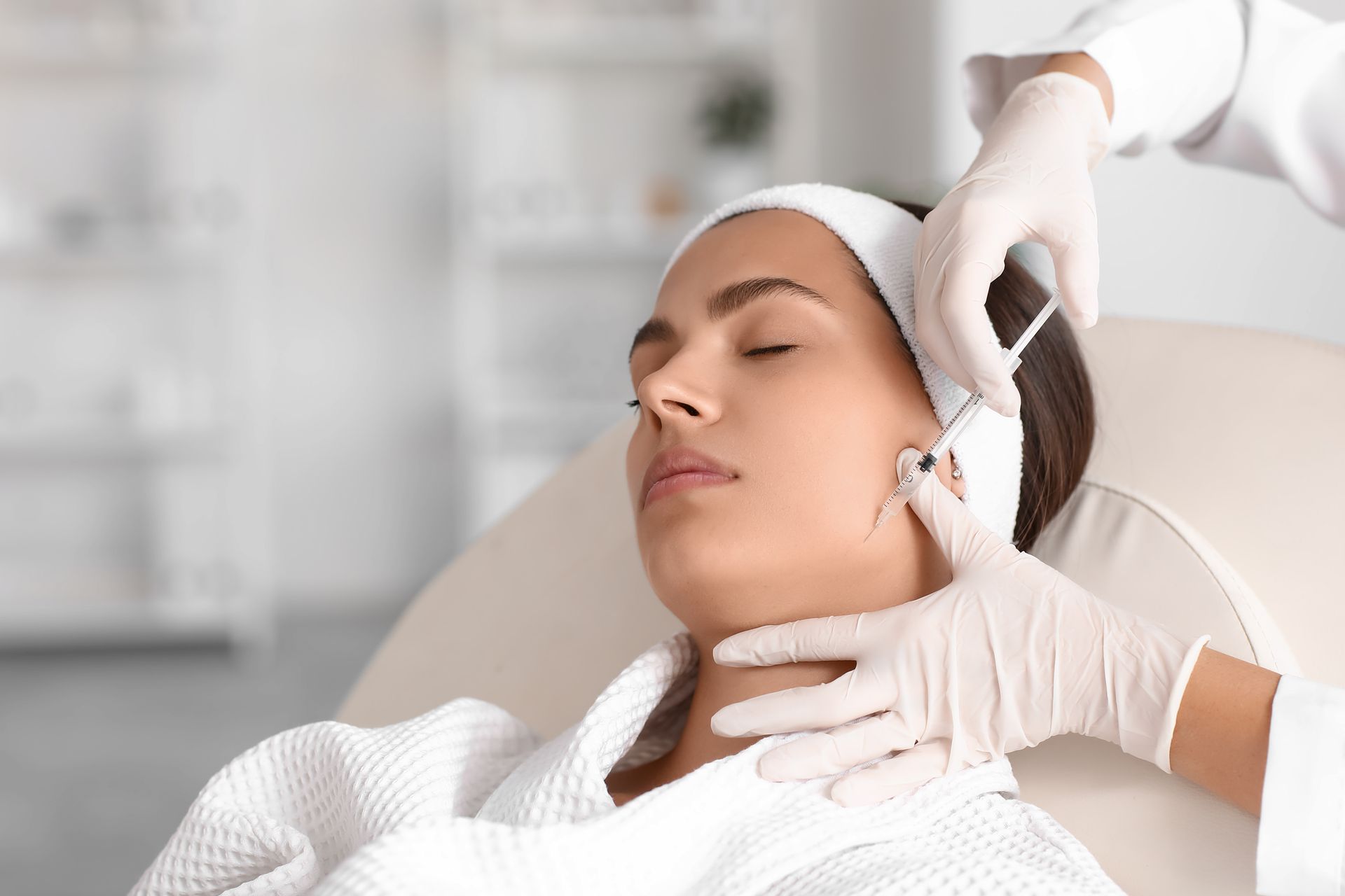 Woman receiving facial injections in a medical setting.